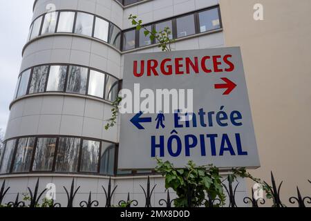 Panneau écrit en français indiquant les directions du service d'urgence et l'entrée piétonne d'un hôpital en France Banque D'Images