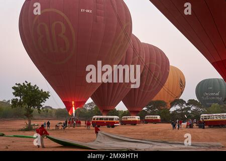 Un groupe de ballons à air chaud rouges se préparant à se lever à l'aube près de Bagan, Myanmar (Birmanie). Banque D'Images