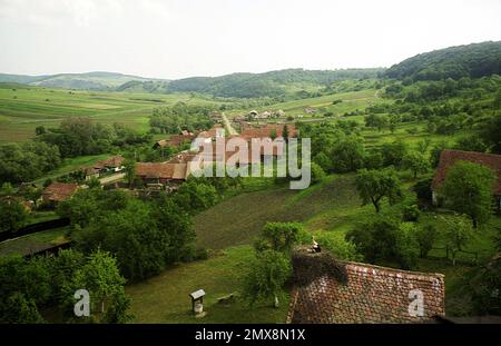 Vue sur le village de Crit dans le comté de Brasov, Roumanie, environ 2001. Un nid de cigognes vu sur un toit de maison. Banque D'Images