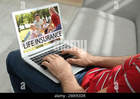 Homme avec un ordinateur portable moderne à l'intérieur, gros plan. Assurance vie Banque D'Images