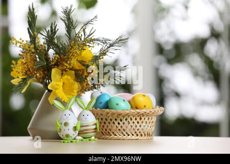 Composition festive avec œufs de Pâques sur la table contre une fenêtre floue, espace pour le texte Banque D'Images