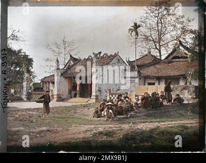 Thanh-Tri, Tonkin, Indochine Un groupe de villageois (principalement des enfants) assis devant le temple bouddhiste, connu sous le nom de "pagode de la maison de rire, Léon occupé à Indochine Banque D'Images