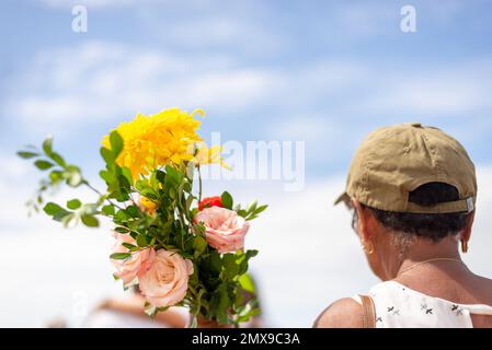 Salvador, Bahia, Brésil - 02 février 2023: Les croyants de la religion camisérable tiennent des fleurs à offrir à Iemanja à Salvador, Bahia. Banque D'Images