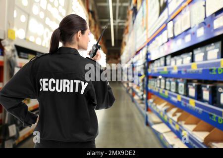 Agent de sécurité utilisant un émetteur radio portable dans le centre commercial, espace pour le texte Banque D'Images