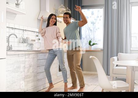 Charmant jeune couple interracial dansant dans leur nouvelle maison Banque D'Images