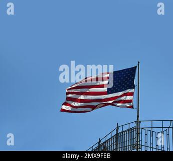 Le drapeau américain flotte dans la brise au sommet de Chimney Rock, parc national de Chimney Rock, Caroline du Nord. Banque D'Images