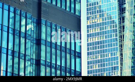 Fragments de bâtiment dans le quartier des affaires de la ville moderne. Immeuble de bureaux en hauteur dans le centre-ville. Architecture moderne de béton typique, verre et s. Banque D'Images