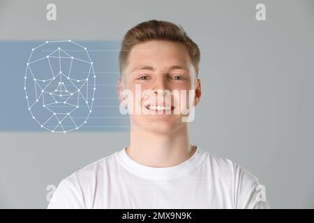 Système de reconnaissance faciale. L'adolescent et la grille d'identification biométrique sur fond gris Banque D'Images