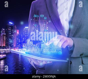 Jeune femme avec tablette et image virtuelle de la ville, gros plan. Technologie moderne Banque D'Images