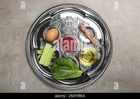 Assiette de Pâque Seder (keara) avec repas symbolique sur table grise, vue de dessus. Fête de Pesah Banque D'Images