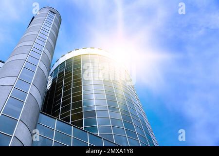 Gratte-ciel moderne avec fenêtres teintées sur ciel bleu, vue en angle bas. Société de construction Banque D'Images