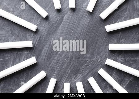 Cadre fait de morceaux de craie blanche sur tableau noir, plat. Espace pour le texte Banque D'Images