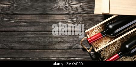 Caisse et bouteilles de vin sur table en bois, plat avec espace pour le texte. Bannière Banque D'Images