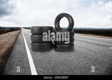 Des piles de pneus de voiture sur les routes asphaltées à l'extérieur Banque D'Images