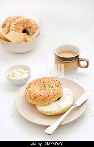 Bagels aux graines avec fromage à la crème et café en format vertical. Petit déjeuner sain et nutritif. Banque D'Images