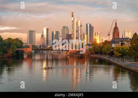 Horizon, gratte-ciels dans le quartier des banques dans la lumière du matin, vieux pont sur le main, rameurs sur la rivière, lever du soleil, automne, Francfort-sur-le-main Banque D'Images