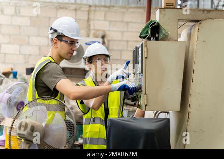 Équipe d'ingénieurs pratiquant la maintenance en prenant soin et en pratiquant la maintenance des anciennes machines en usine afin qu'elles puissent être utilisées en continu. Banque D'Images