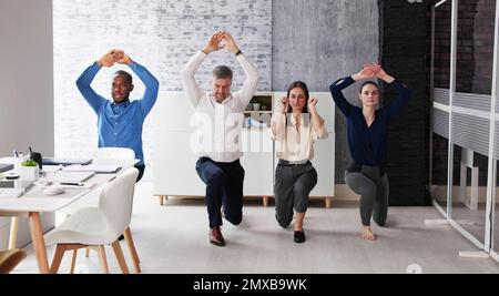 Des jeunes gens d'affaires heureux qui font de l'exercice d'étirement au bureau Banque D'Images