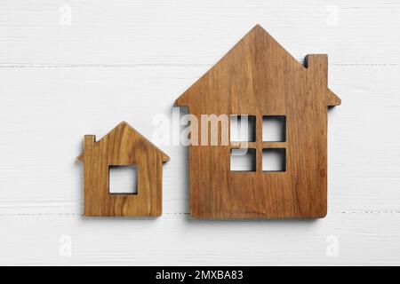 Petites et grandes figures de maison sur fond blanc en bois, plat. Concept de principe de Pareto Banque D'Images