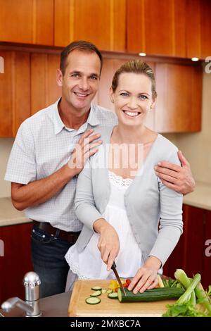 Miel mi h.... faim. Un portrait d'un couple heureux debout et de la cuisine dans leur cuisine. Banque D'Images