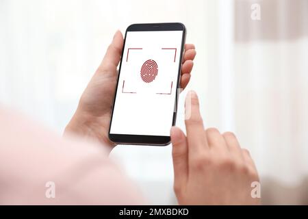 Femme tenant un smartphone avec lecteur d'empreintes digitales à l'intérieur, en gros plan. Identité numérique Banque D'Images