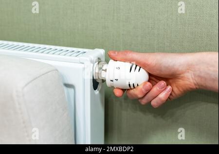 Tourner manuellement le chauffage avec le bouton de la soupape du radiateur d'origine, en réglant la température intérieure. Concept de consommation d'énergie. Photo de haute qualité Banque D'Images