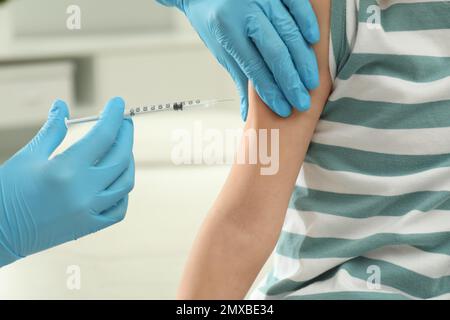 Médecin vaccinant petit enfant dans une clinique, closeup Banque D'Images