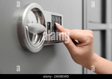 Femme entrant le code sur le clavier de coffre-fort moderne, gros plan Banque D'Images