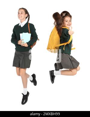 Les enfants en uniforme scolaire sautant sur fond blanc Banque D'Images