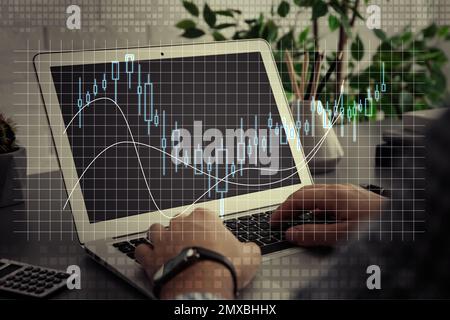 Commerce de Forex. Homme travaillant avec un ordinateur portable à la table et au tableau, gros plan Banque D'Images