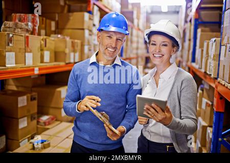 Statut de la commande livrée. Portrait d'un homme et d'une femme qui inspectent l'inventaire dans un grand entrepôt de distribution. Banque D'Images