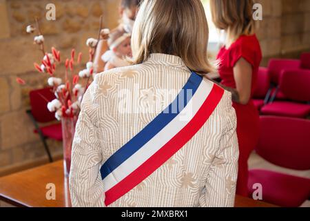 Femme blonde française maire avec foulard drapeau de france tricolore et robe rose lors de la célébration officielle à l'hôtel de ville Banque D'Images