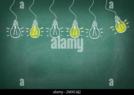 Concept d'idée. Ampoules dessinées sur tableau noir vert Banque D'Images