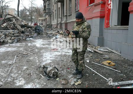 KRAMATORSK, UKRAINE - le 2 FÉVRIER 2023 - un militaire de l'EOD se tient à côté d'un fragment d'un missile russe qui a détruit un immeuble résidentiel de quatre étages Banque D'Images