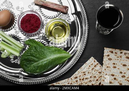 Composition de la pose plate avec plaque de Pâque Seder (keara) sur table noire. Fête de Pesah Banque D'Images