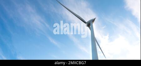 parc éolien ou ferme de moulin à vent de bannière floue, avec des éoliennes à fort vent pour la production d'électricité. Concept de production d'énergie verte. Les développeurs durables Banque D'Images