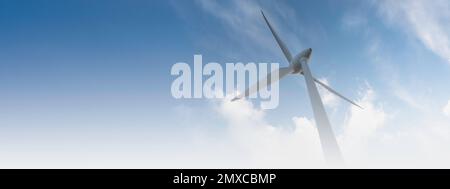 parc éolien ou ferme de moulin à vent de bannière floue, avec des éoliennes à fort vent pour la production d'électricité. Concept de production d'énergie verte. Les développeurs durables Banque D'Images