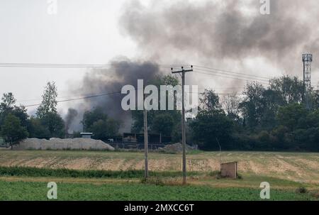 Fumée sortant d'un incendie grave sur une petite propriété industrielle située dans les terres agricoles du Suffolk Banque D'Images