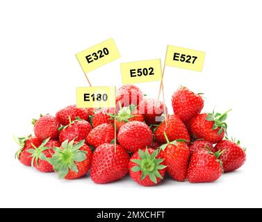 Fraises mûres avec numéros E sur fond blanc. Additifs alimentaires nocifs Banque D'Images