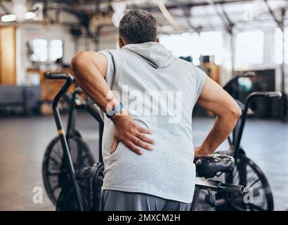 Sports, gym et blessures, vieil homme avec douleur au dos, urgence pendant l'entraînement au studio de fitness. Santé, bien-être et inflammation, personne âgée avec la main Banque D'Images
