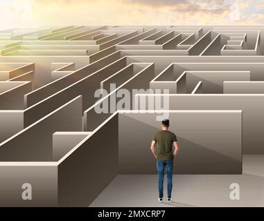 Jeune homme essayant de trouver un moyen de sortir du labyrinthe Banque D'Images