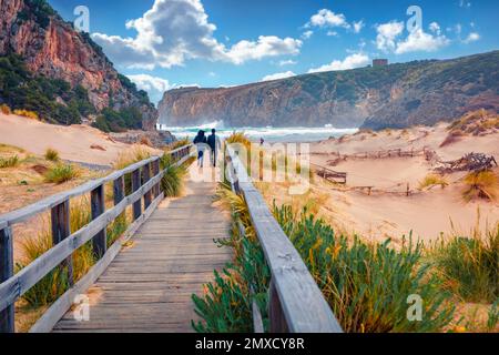 Les Toristes marchent jusqu'à la plage de Cala domestica sur une jetée en bois. Scène d'été venteuse de la Sardaigne, Italie, Europe. Passerelle dans Canyon di Cala domestica. Beautif Banque D'Images