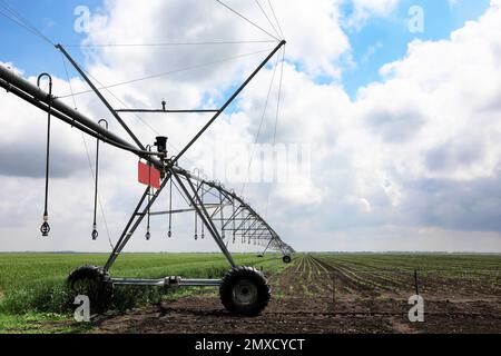 Système d'irrigation moderne dans le champ sous ciel nuageux. Équipement agricole Banque D'Images