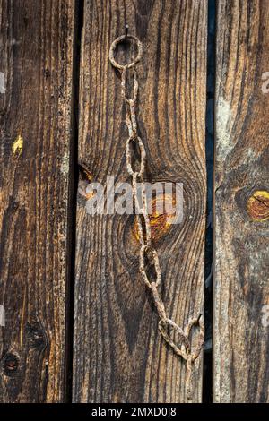 chaîne en fer rouillé sur le fond d'une vieille planche en bois, texture. Banque D'Images