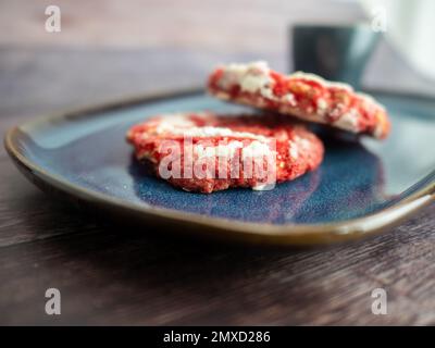 petits gâteaux doux en velours rouge sur un plateau bleu sur fond de bois macro gros plan Banque D'Images