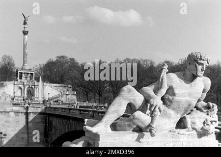 Luitpoldbrücke über der Isar, auch, Prinzregentenbrücke Steinskulptur und mit Bayern darstellender Friedensdenkmal im Hintergrund, 1957. Pont Luitpold, également connu sous le nom de Prince Regent Bridge, traversant la rivière Isar, avec une sculpture en pierre représentant la Bavière et l'Ange de la paix dans l'arrière-plan, 1957. Banque D'Images