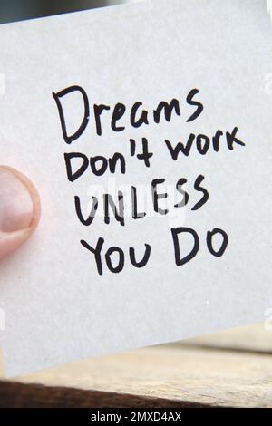 Inscription de citations motivationnelles sur une balise. Les rêves ne fonctionnent pas à moins que vous ne le fassiez. Banque D'Images