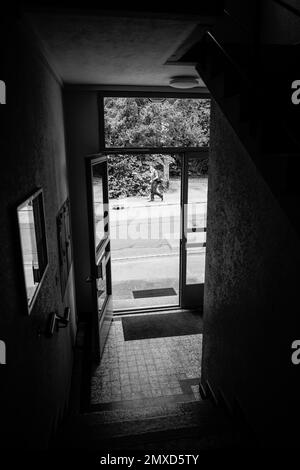 Une porte d'entrée d'un bâtiment à Nyon Suisse dans une rue noire et blanche à l'allure vintage de la route Banque D'Images