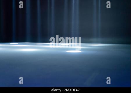 rayons de lumière flous sur le sol de la discothèque. projecteurs au néon bleu blanc. lignes laser et effet d'éclairage. scène vide de nuit en studio avec refle néon Banque D'Images