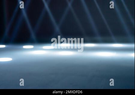 rayons de lumière flous sur le sol de la discothèque. projecteurs au néon bleu blanc. lignes laser et effet d'éclairage. scène vide de nuit en studio avec refle néon Banque D'Images